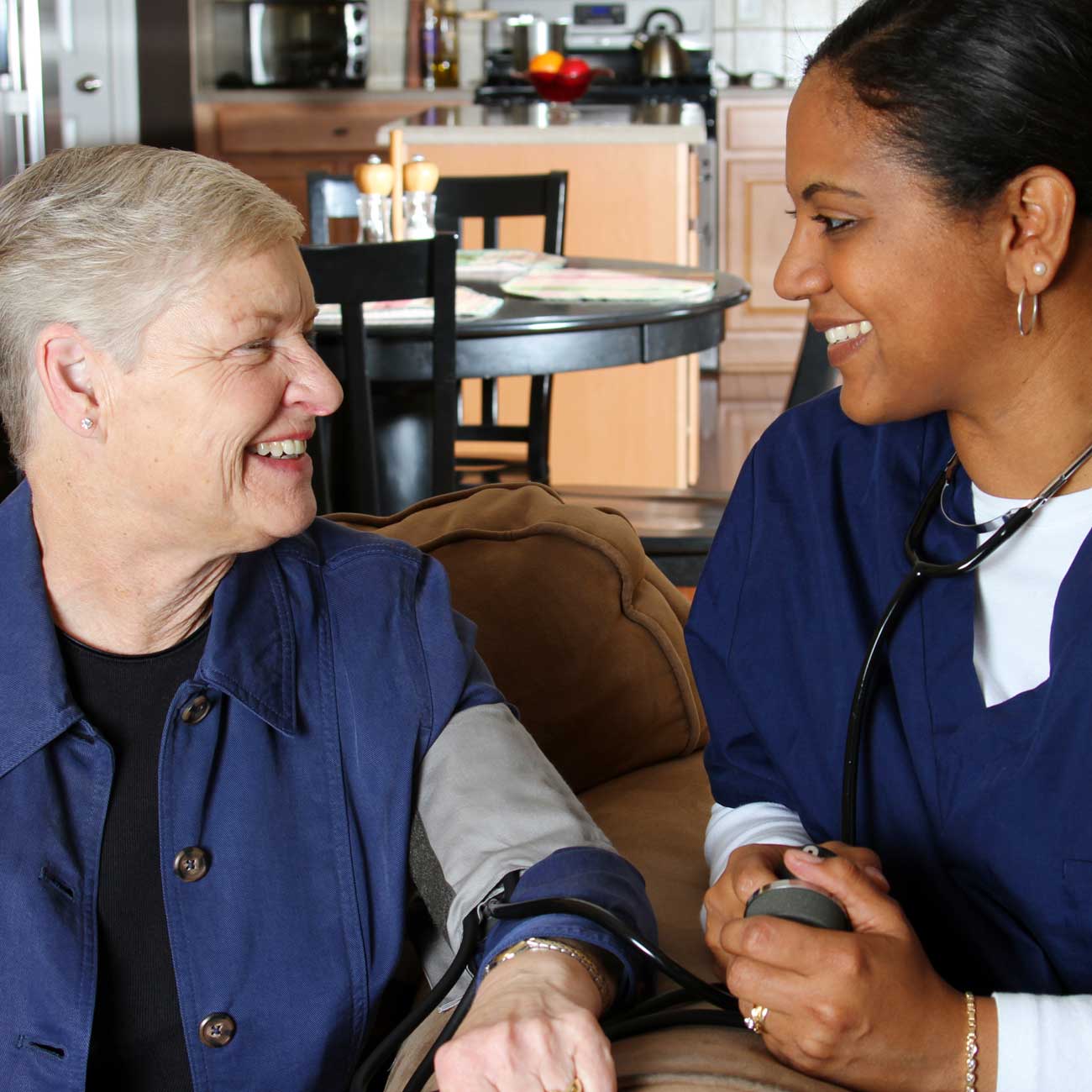 Home health nurse taking a client's blood pressure.